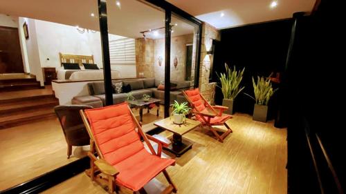 a living room with orange chairs and a couch at La Vista - Un lugar de Ensueño in Samaipata