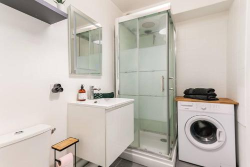 ein Badezimmer mit einer Waschmaschine und einer Glasdusche in der Unterkunft A Deux Pas de la Magie - Idéal DisneyLand & Paris in Bussy-Saint-Georges