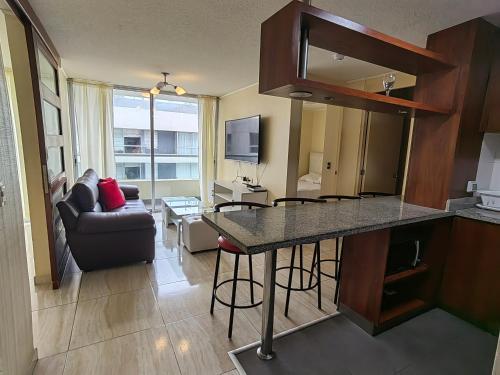 cocina y sala de estar con mesa y sofá en Romántico departamento con Vista al Mar, en Lima