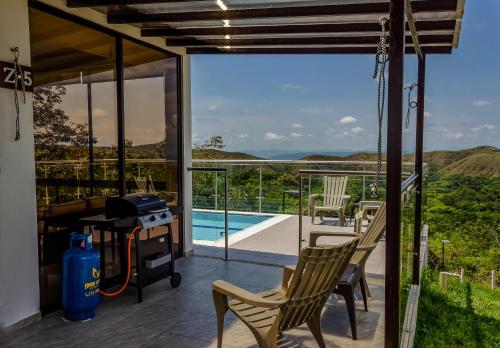 a patio with chairs and a grill and a pool at Casas Campestres Los Miradores de Fruworld in Carmen de Apicalá