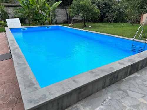 a swimming pool with blue water in a yard at GARRIOTT TBILISI in Tbilisi City