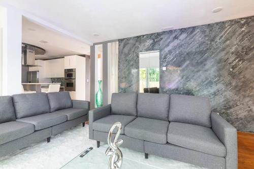 - un salon avec deux canapés et un mur en pierre dans l'établissement Blue Ocean Vacation Home 1, à Fort Lauderdale