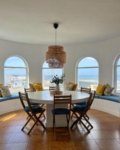 a dining room with a table and chairs and the ocean at Casa Cabrera - 2 apartamentos con vistas al mar in Caleta de Caballo
