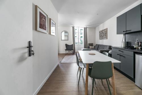 a kitchen and living room with a white table and chairs at Résidence Aristide Briand - Appartements en Centre Ville in Vichy