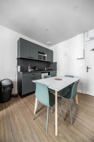 a kitchen with a table and chairs in a room at Résidence Aristide Briand - Appartements en Centre Ville in Vichy