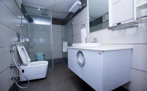 a white bathroom with a sink and a toilet at Hotel Aura IP Grand Karkardooma Metro Station New Delhi Couple friendly in New Delhi