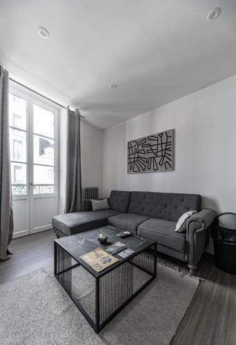 a living room with a couch and a coffee table at Résidence Aristide Briand - Appartements en Centre Ville in Vichy