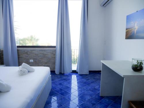 a room with two beds and a desk and a window at B&B Al Vecchio Pontile Sea View in Marsala