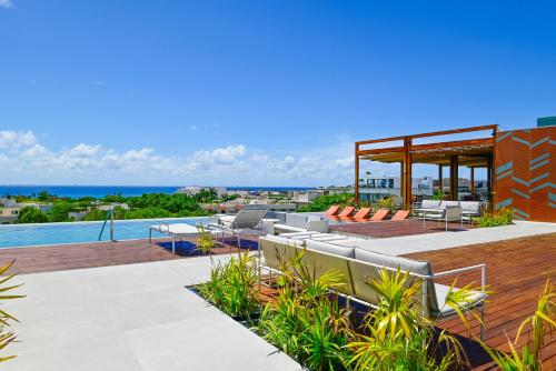 an outdoor patio with furniture and a swimming pool at Aloft Playa del Carmen in Playa del Carmen