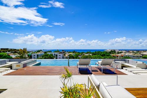 a swimming pool with two lounge chairs on a deck at Aloft by Marriott Playa del Carmen in Playa del Carmen