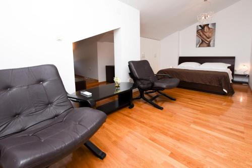 a living room with a couch and a desk and a bed at Apartment Marin in Rogoznica