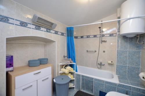 a bathroom with a shower and a toilet and a tub at Apartments Lory in Rabac