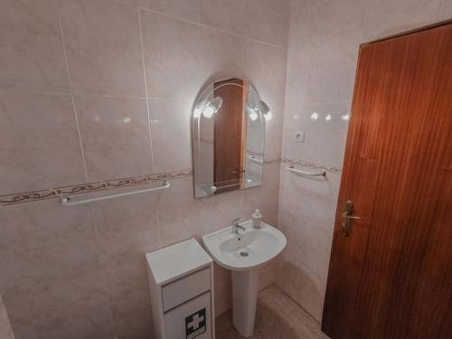 a bathroom with a sink and a mirror at Apartamento para férias-Nazaré in Nazaré