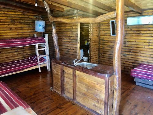 a bathroom with a sink in a log cabin at CABAÑAS COSTA RIBERA in Timbues