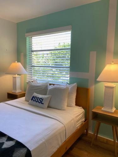 Seaspray Surf Lodge في فيرو بيتش: غرفة نوم بسرير ومصباح ونافذة
