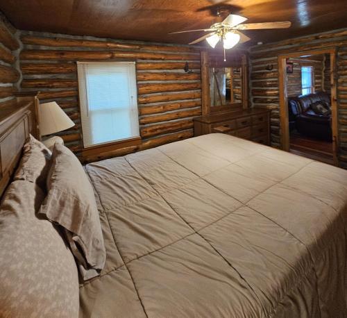 Two Bears في رويدوسو: غرفة نوم مع سرير كبير في كابينة خشب