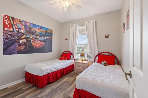 um quarto com duas camas e um quadro na parede em Mickey's Whimsical Wonderland em Kissimmee