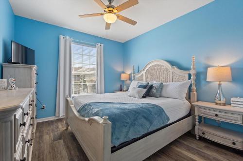 a blue bedroom with a bed and a ceiling fan at Mickey's Whimsical Wonderland in Kissimmee