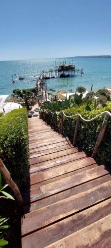 a wooden pathway leading to a beach with a pier at L'uliveto sui Trabocchi in Fossacesia