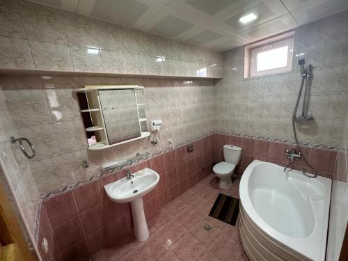 a bathroom with a sink and a tub and a toilet at GARRIOTT TBILISI in Tbilisi City
