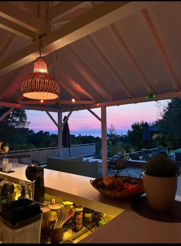 a kitchen counter with a bowl of fruit and a pendant light at Sanidiamonds in Sani Beach