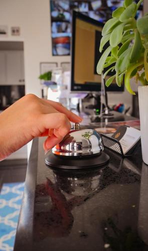 a hand is touching a computer mouse on a desk at Hotel StayHome in Ensenada