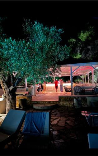 a group of people sitting on a patio next to a tree at Sanidiamonds in Sani Beach