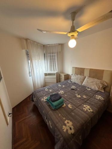 een slaapkamer met een bed en een plafondventilator bij Departamento Cañada Completo in Cordoba