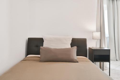 un letto con due cuscini sopra in una stanza di Modernes ruhiges Apartment mit Ausblick nahe FernUni - Viele Parkplätze a Hagen