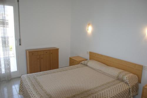 レスカラにあるEls Pins - L'Escalaのベッドルーム1室(ベッド1台、ドレッサー、窓付)