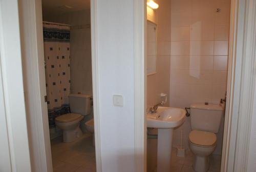 a bathroom with two toilets and a sink at Els Pins - L'Escala in L'Escala