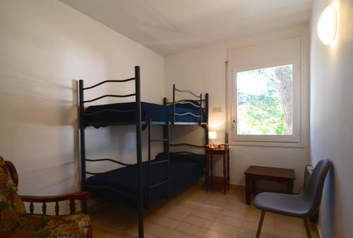 Zimmer mit 3 Etagenbetten und einem Fenster in der Unterkunft Puig Padro 4 1-1 in L'Escala