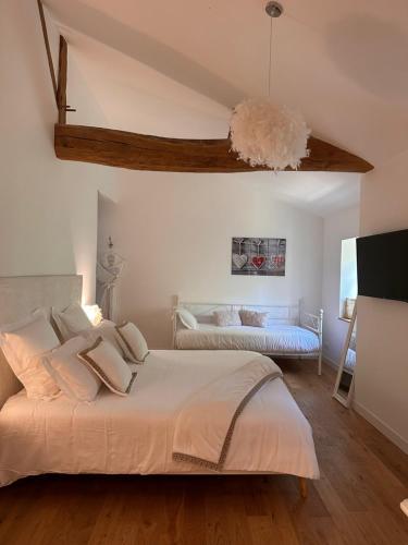 een slaapkamer met een groot wit bed in een kamer bij LE CARGE D’ARLAY in Charnay-lès-Mâcon