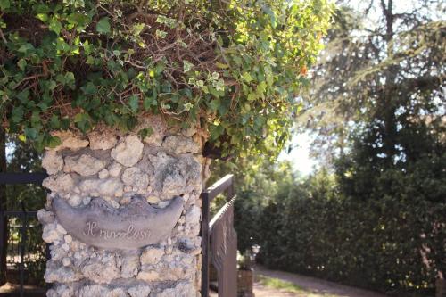 a stone wall with a sign on it at il nuvoloso in Città della Pieve