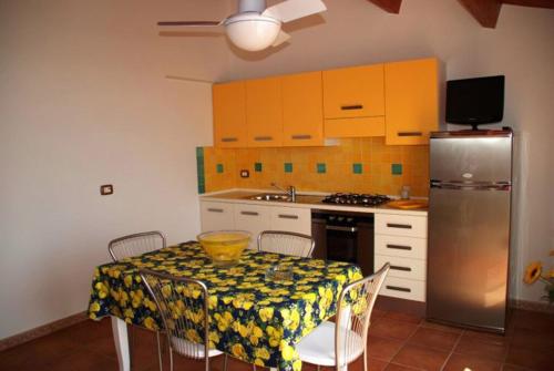 een keuken met een tafel en een koelkast bij Casa Adelaide in Santa Croce Camerina
