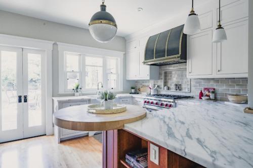 a kitchen with white cabinets and a marble counter top at 1907 Stone House - King Bed, Office, Crib, Toys in San Diego