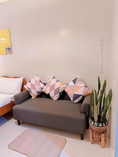 a couch with pillows in a living room at Luxury Suites at Brenthill Baguio City in Baguio