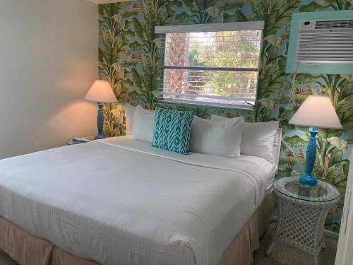 a bedroom with a white bed with two lamps at Seaspray Surf Lodge in Vero Beach