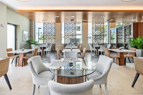 a dining room with tables and chairs and windows at Palácio Estoril Hotel, Golf & Wellness in Estoril