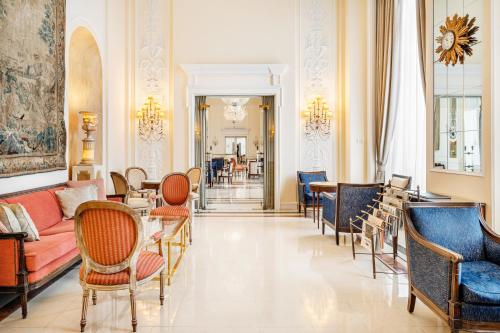 a lobby with chairs and a couch and tables at Palácio Estoril Hotel, Golf & Wellness in Estoril