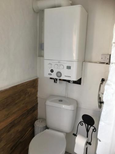 a small bathroom with a white toilet and a water tank at Pipers Cottage - Quirky Cottage near Ironbridge! in Broseley