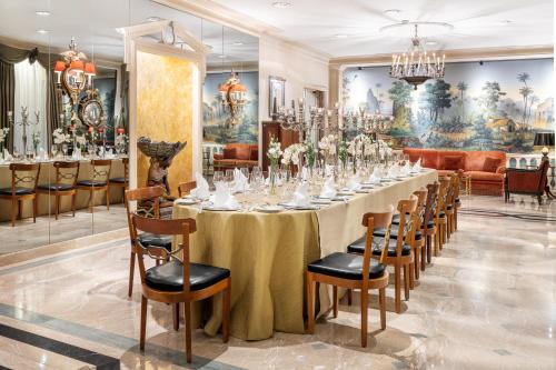 a long dining room with a long table and chairs at Palácio Estoril Hotel, Golf & Wellness in Estoril