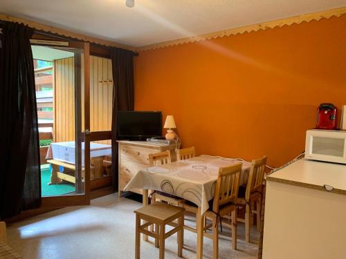 une salle à manger avec une table et des chaises et une cuisine dans l'établissement Studio cabine près navette, balcon exposé sud - FR-1-679-6, à Morzine