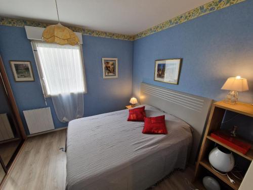 a bedroom with a bed with red pillows on it at Chatelaillon-Plage Centre-Ville: Apt 4 pers, balcon, parking, piscine, wifi - FR-1-706-21 in Châtelaillon-Plage