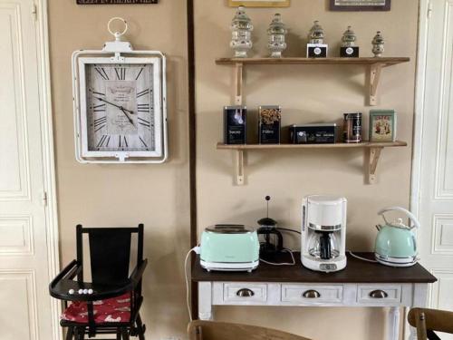 une chambre avec une table et une horloge sur le mur dans l'établissement Charmant Gîte Familial avec Jardin Privatif et Confort Moderne, au Cœur de la Touraine - FR-1-381-550, à Sepmes