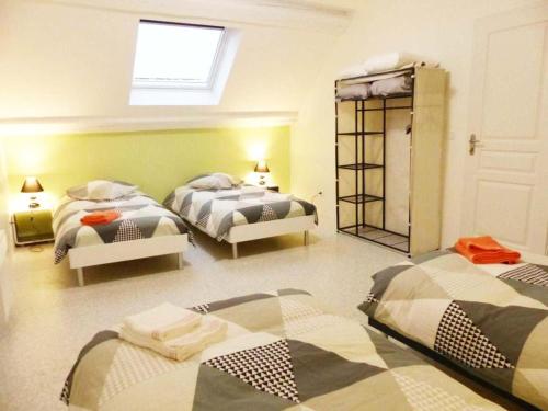 1 Schlafzimmer mit 3 Betten und einem Spiegel in der Unterkunft Gîte Louroux-de-Bouble, 5 pièces, 12 personnes - FR-1-489-477 in Louroux-de-Bouble