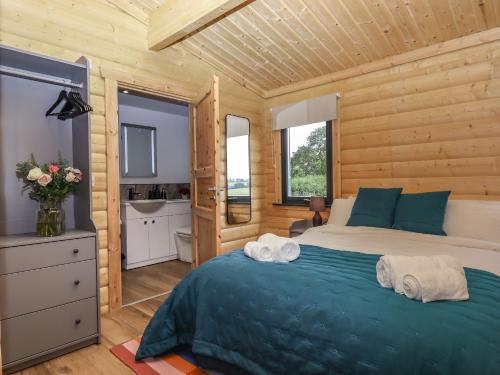 a bedroom with a bed in a wooden cabin at Foxglove Lodge in Exeter