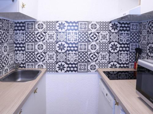 - une cuisine avec du carrelage noir et blanc sur le mur dans l'établissement Studio skis aux pieds, 6 pers, cheminée, billard, WIFI, centre Les Orres - FR-1-322-534, aux Orres
