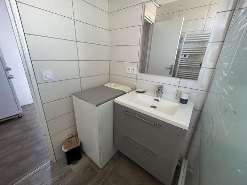 une salle de bain avec un lavabo et un miroir dans l'établissement T2 Cabine Climatisé 6 Couchages avec Parking - Port Camargue - FR-1-250-260, au Grau-du-Roi