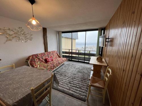 un salon avec un canapé et une table dans l'établissement Appartement 3 pièces avec parking en centre station - FR-1-593-91, aux Angles